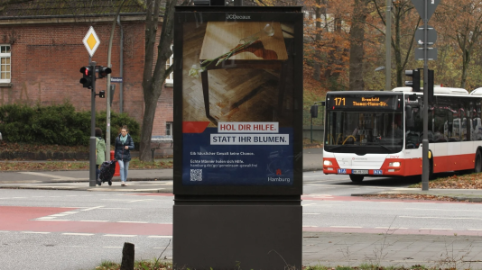 Ein Werbeplakat mit der Schrift "Hol dir Hilfe statt ihr Blumen"