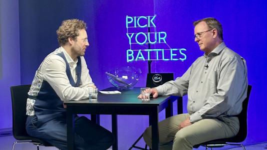 Foto von Jan Philipp Albrecht und Bodo Ramelow vor einem Neon-Schriftzug "Pick Your Battles"